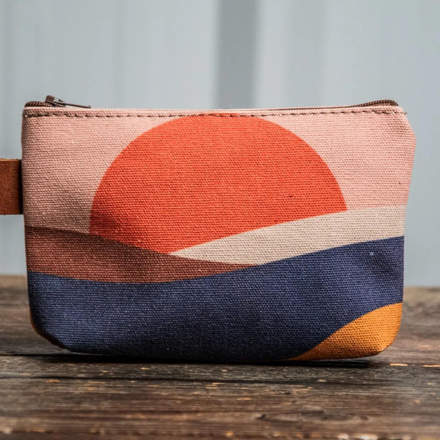 Fabric pouch with a sunset design on a wooden surface from sandpeople 